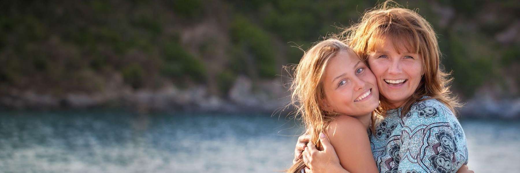 A mother and daughter hugging by a lake | kurri kurri dentist