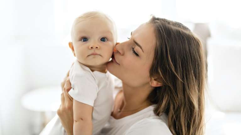 A mother kissing her baby | children's dental care
