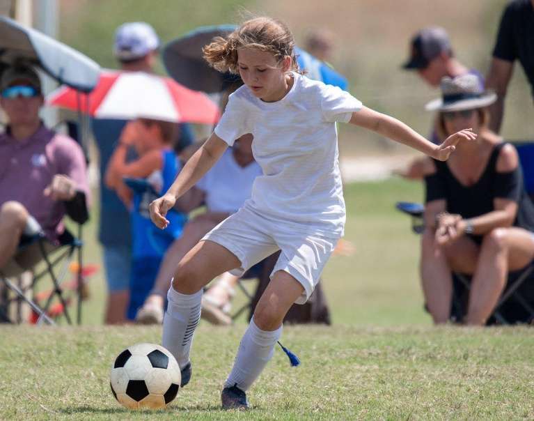A girl playing soccer | oral health Raymond Terrace