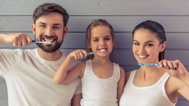 A smiling family brushing their teeth for dental hygiene in Raymond Terrace