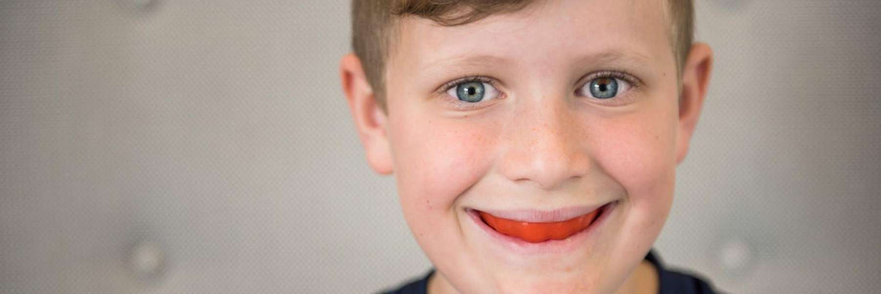 A smiling boy wearing a mouthguard