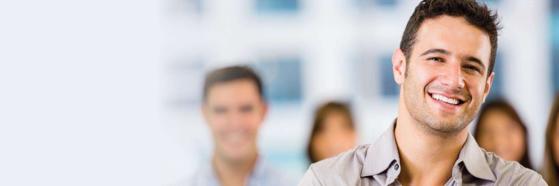 A smiling man in a classroom | dentist in Raymond Terrace and Kurri Kurri