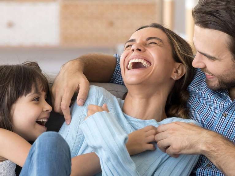 A laughing family on the couch