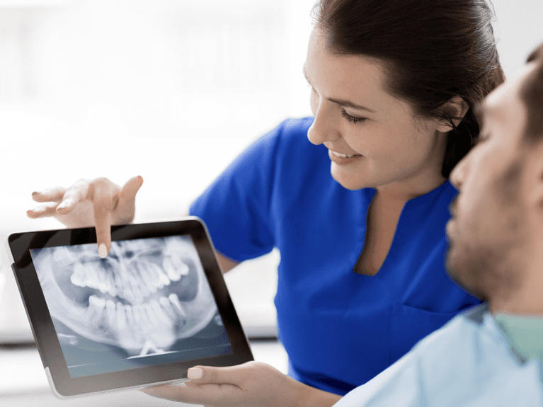 A dentist showing a patient their dental x-rays